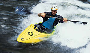 Back view of a woman kayaking along a beautiful tropical jungle river.
