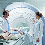 Male and female doctors preparing patient for MRI scan in hospital